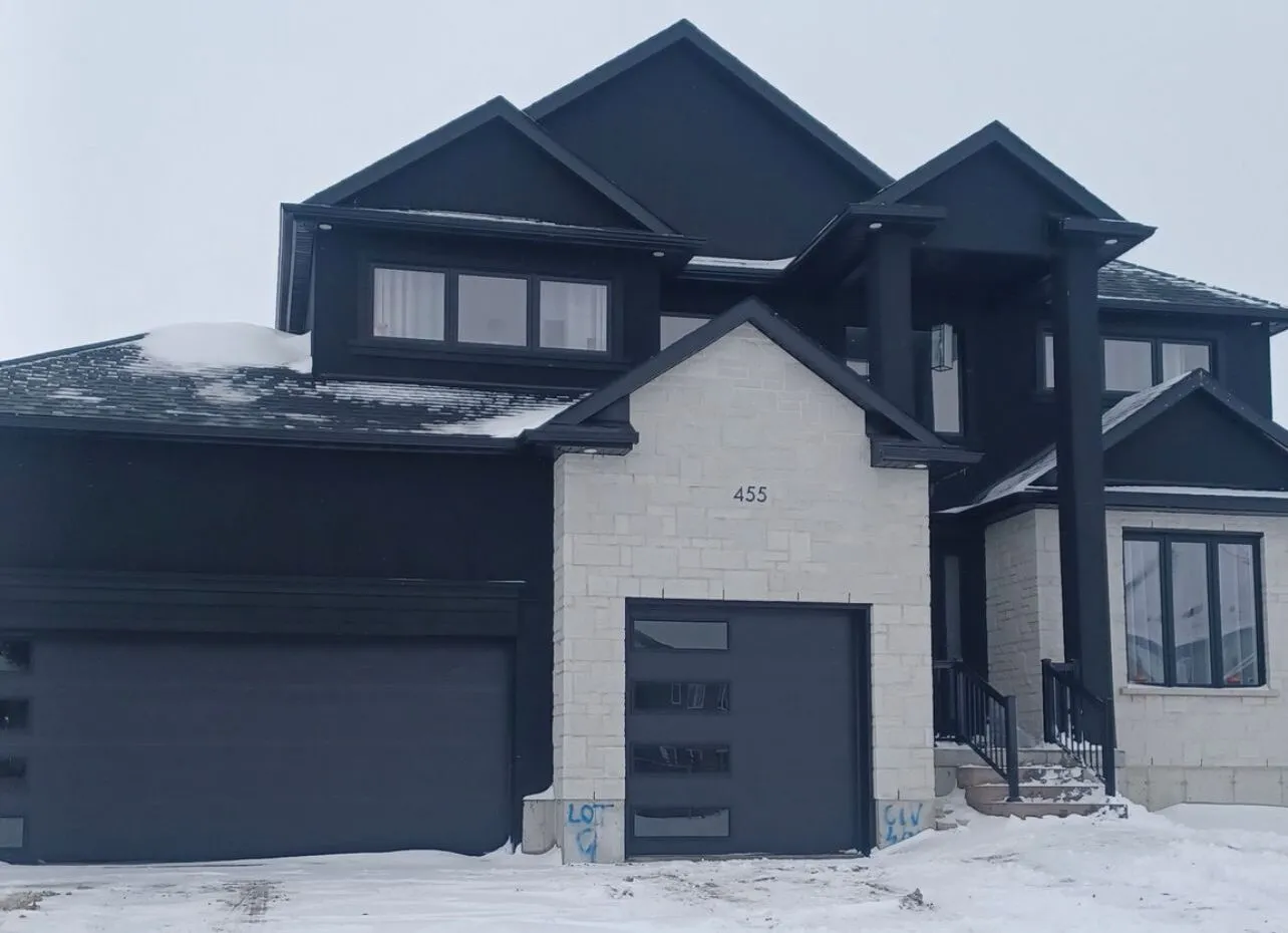 Custom home in dark stucco and white limestone by Mask Stucco